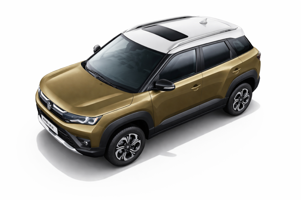 Maruti Suzuki Brezza का गोल्डन कलर कॉम्पैक्ट SUV मॉडल, सफेद रूफ और सनरूफ के साथ, ऊपर से थ्री-क्वार्टर एंगल में दिखाई देता हुआ।
